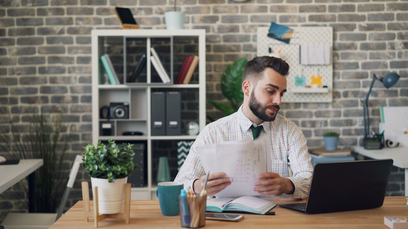 business owner calculating software costs spreadsheet