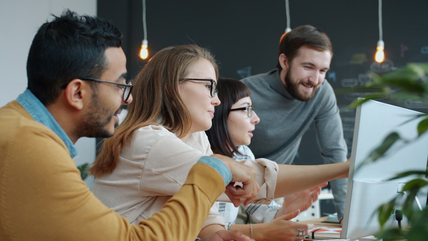 sales team reviewing pipeline data on large monitor